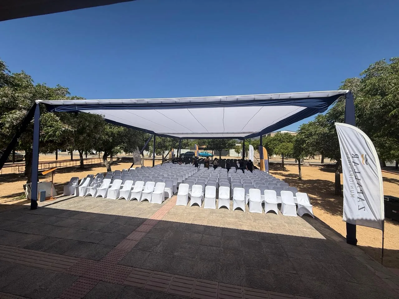Montaje para eventos corporativos con sillas y estructura de sombra