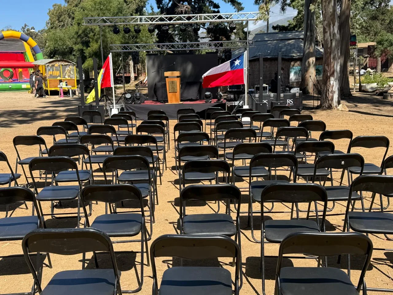 Sillas y escenario preparados para evento al aire libre